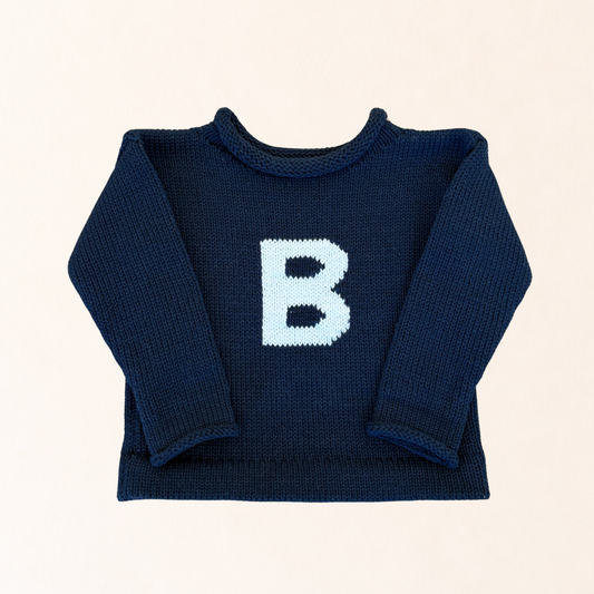 Navy blue sweater with a white 'B' on a beige background