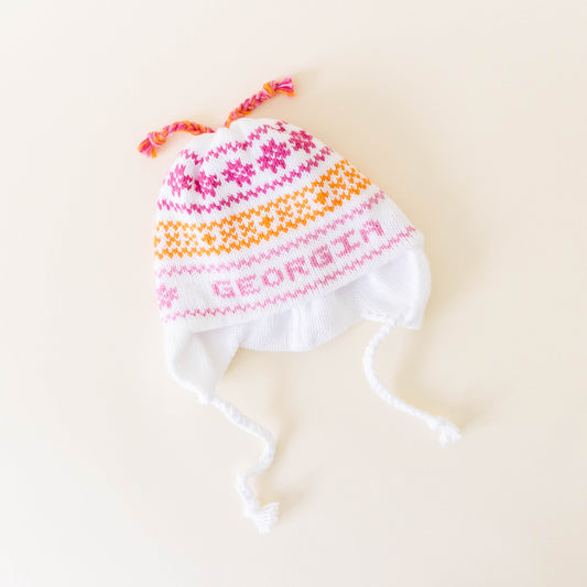 White knit hat with pink and orange stitching personalize with the name "Georgia" on a neutral background