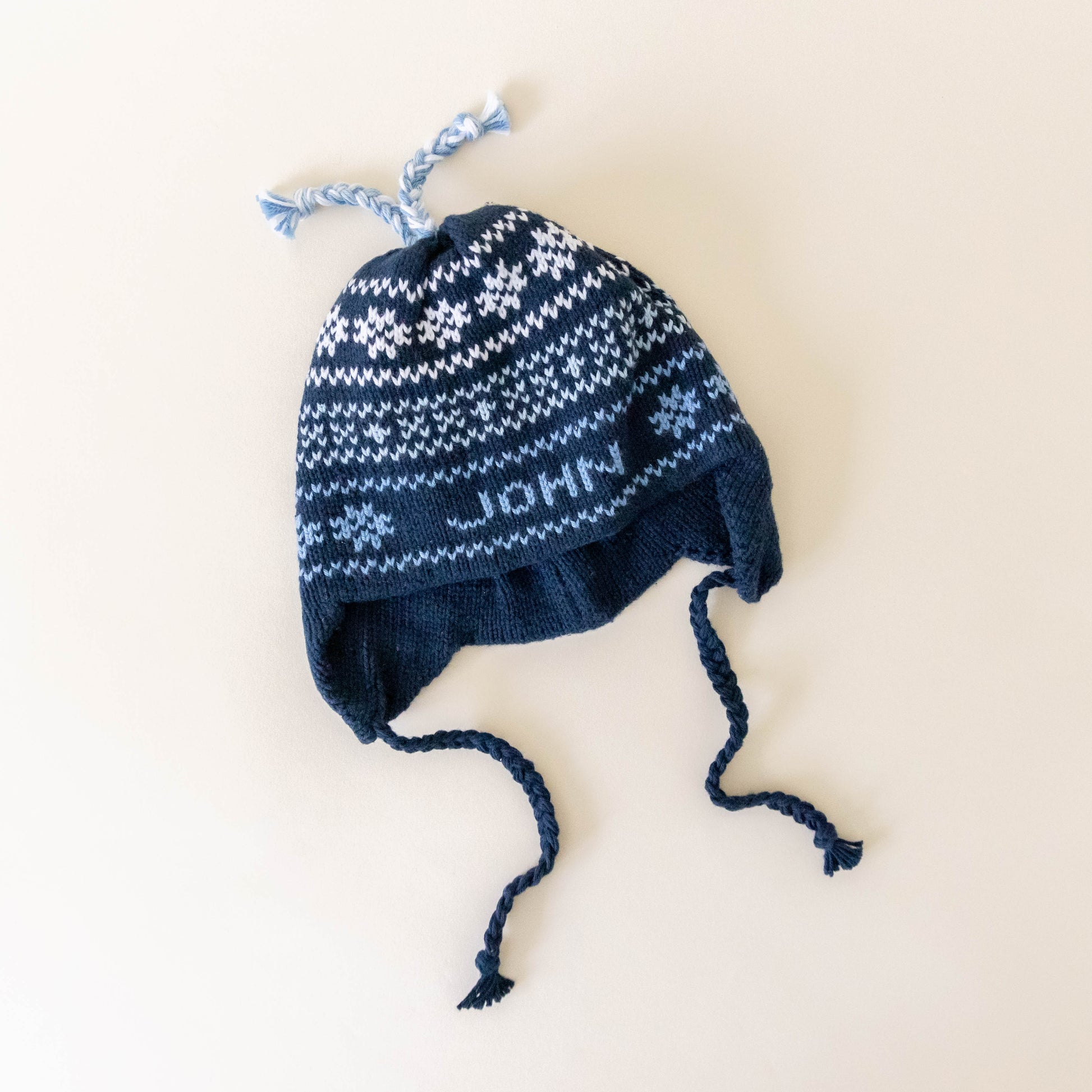 Navy knit hat on a neutral background laying flat