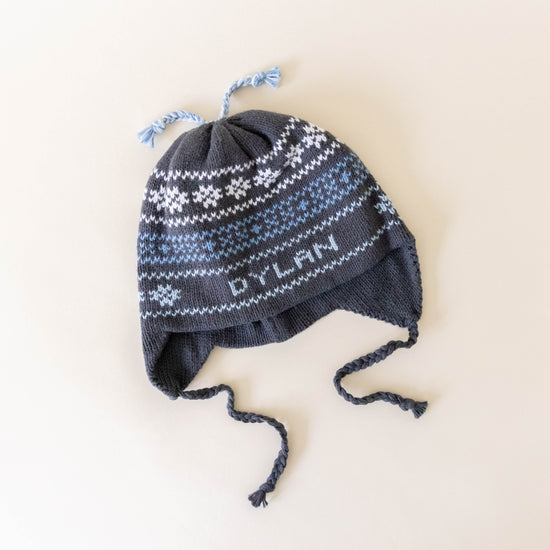 Grey knit hat on a neutral background laying flat