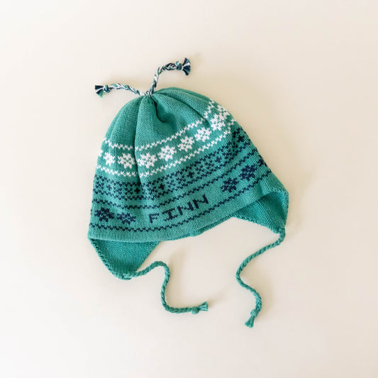 Green knit hat personalized with the name "Finn" on a neutral background