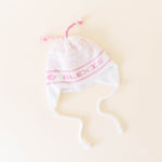 White knit hat with pink stitching personalized with the name 