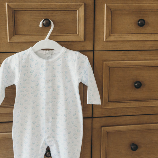 Elephant onesie in blue hanging on a dresser drawer knob closer up