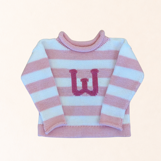 Pink and white striped sweater with a letter 'W' on a light pink background